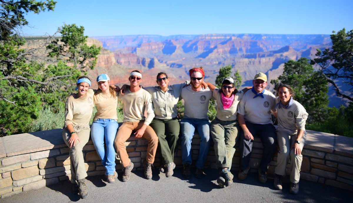 Joyful tour group posing together in Grand Canyon National Park