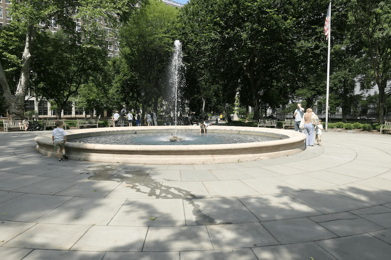 Children play in the center fountain of Washington Square