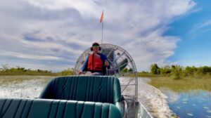 ACE Member Julia Izzo drives an airboat through the marsh. Photo credit: Ian Jin/USFWS