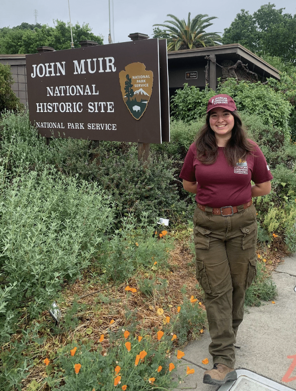 ACE member Ava standing by NPS sign